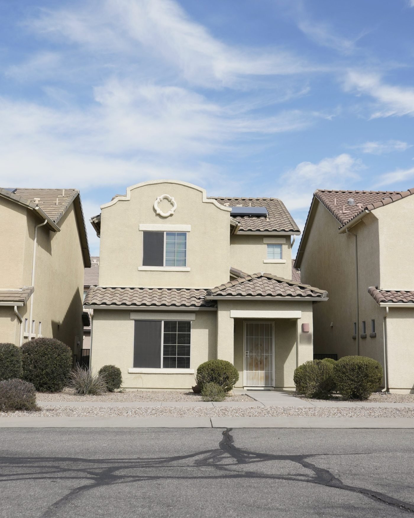 Two-story stucco home with gravel desert landscaping in a Tucson neighborhood