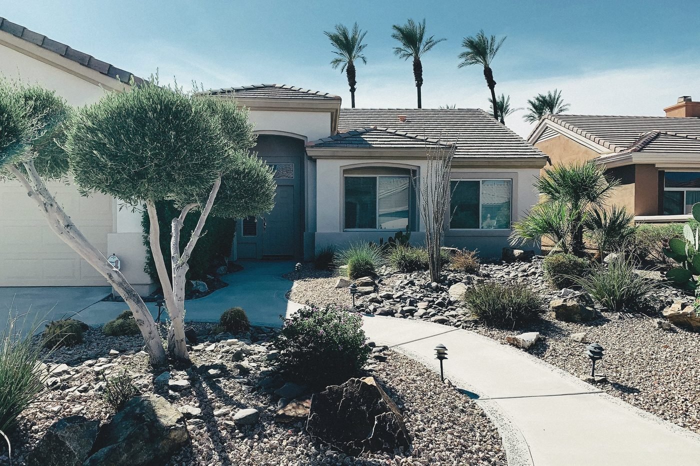 Single-story stucco home with rock and ocotillo desert landscaping